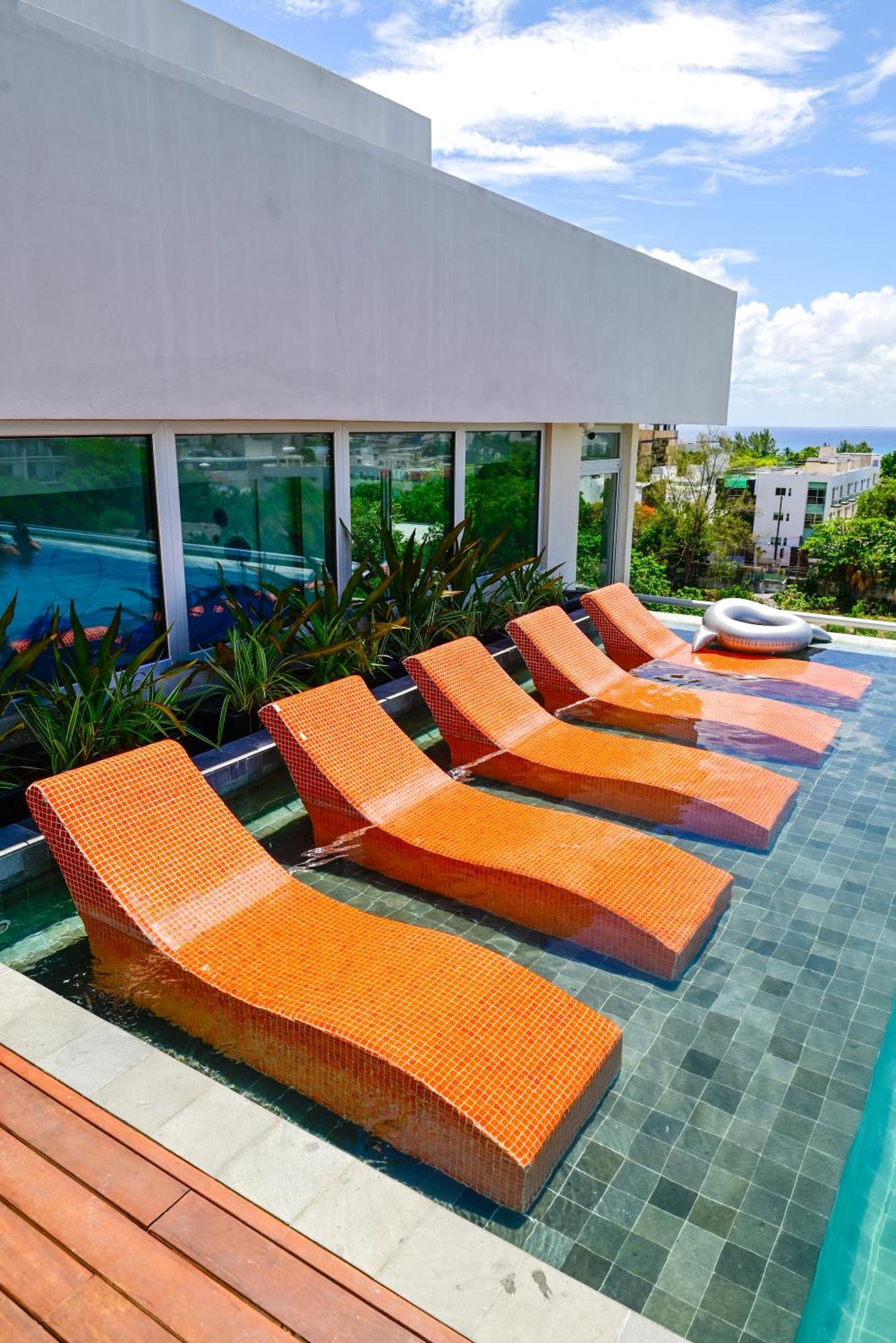 Aloft Playa Del Carmen Hotel Luaran gambar Sunbathing chairs at a pool